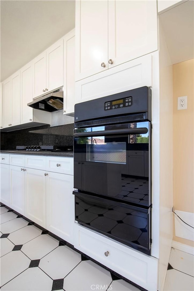10345 Encino Ave, Granada Hills, CA 91344 - kitchen with black oven, under cabinet range hood, white cabinetry, gas cooktop, and dark countertops