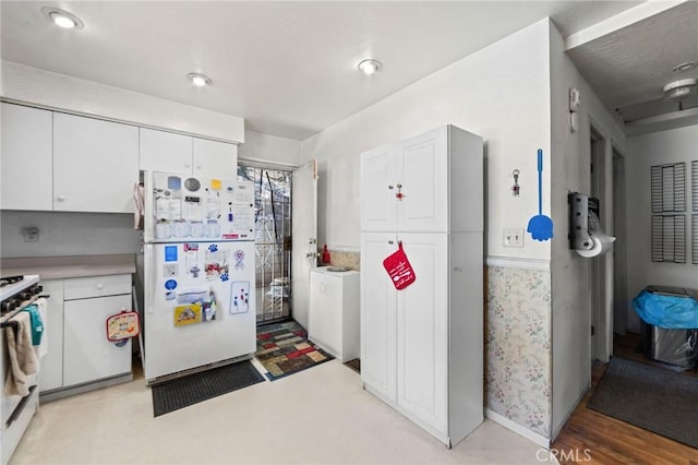 23034 Cedar Way, Crestline, CA 92325 - kitchen with freestanding refrigerator, stove, white cabinets, and light countertops