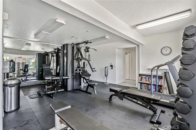 120 The Unit 210, Redondo Beach, CA 90277 - exercise room featuring a textured ceiling and baseboards