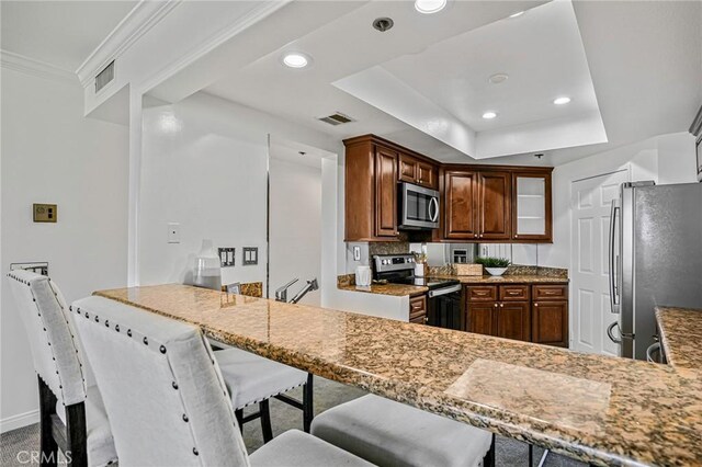 120 The Unit 210, Redondo Beach, CA 90277 - kitchen with stainless steel appliances, recessed lighting, a peninsula, a raised ceiling, and a breakfast bar area