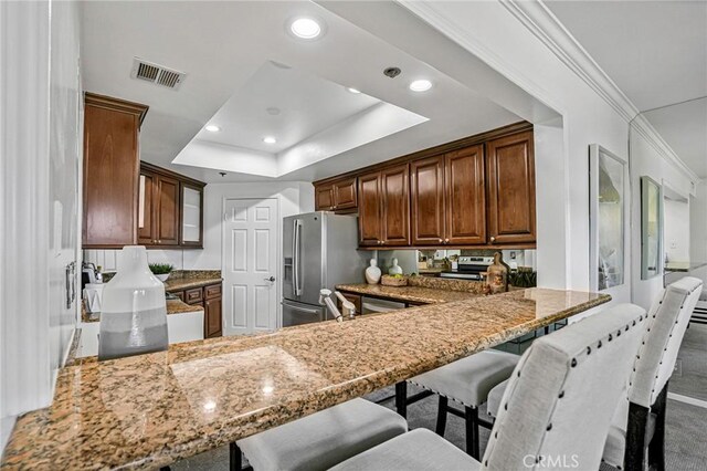 120 The Unit 210, Redondo Beach, CA 90277 - kitchen featuring stainless steel fridge with ice dispenser, a peninsula, recessed lighting, light stone counters, and a tray ceiling