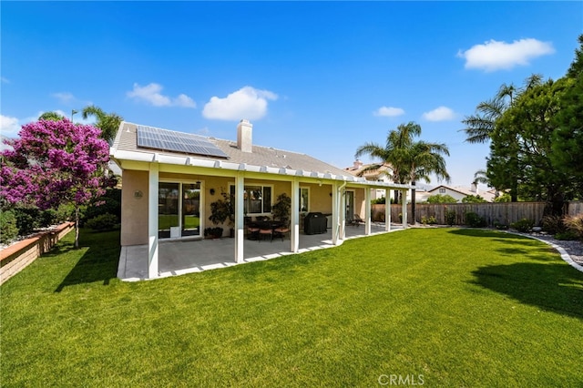14067 Glendale Ct, Rancho Cucamonga, CA 91739 - rear view of property featuring roof mounted solar panels, a patio, stucco siding, and a chimney