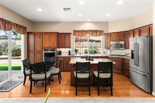 14067 Glendale Ct, Rancho Cucamonga, CA 91739 - kitchen with appliances with stainless steel finishes, plenty of natural light, tasteful backsplash, recessed lighting, and light wood-style flooring