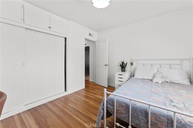 569 S Fenimore Ave, Covina, CA 91723 - bedroom with wood finished floors, ornamental molding, arched walkways, and a closet