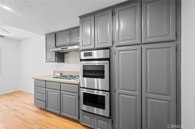 4320 Glencoe Ave Unit 2, Marina Del Rey, CA 90292 - kitchen featuring gray cabinets, double oven, white gas cooktop, light wood-style floors, and under cabinet range hood