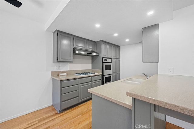 4320 Glencoe Ave Unit 2, Marina Del Rey, CA 90292 - kitchen featuring gray cabinetry, under cabinet range hood, white appliances, a peninsula, and light wood-style floors