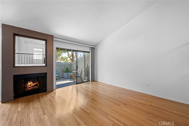 4320 Glencoe Ave Unit 2, Marina Del Rey, CA 90292 - unfurnished living room featuring a warm lit fireplace, wood finished floors, and lofted ceiling