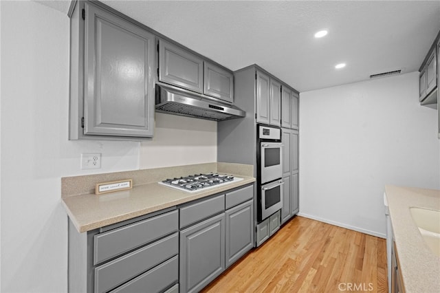 4320 Glencoe Ave Unit 2, Marina Del Rey, CA 90292 - kitchen featuring gray cabinetry, white gas stovetop, under cabinet range hood, double oven, and light wood-style floors