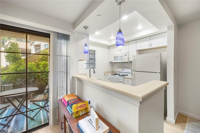 1068 Calle Del Cerro Unit 1521, San Clemente, CA 92672 - kitchen featuring white appliances, white cabinetry, a raised ceiling, decorative light fixtures, and a peninsula