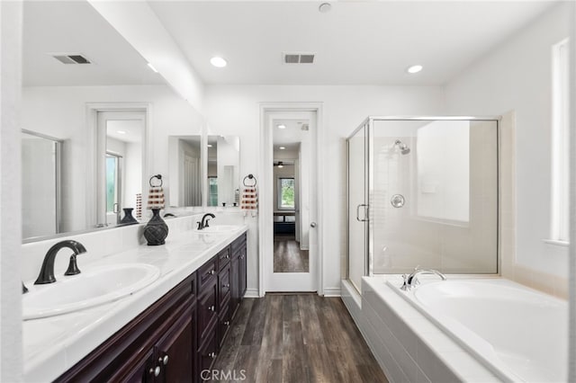 982 Camino Del Arroyo Dr Unit 49, San Marcos, CA 92078 - bathroom with double vanity, a bath, wood finished floors, a shower stall, and recessed lighting