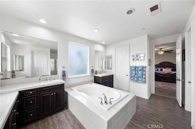 982 Camino Del Arroyo Dr Unit 49, San Marcos, CA 92078 - full bath with ensuite bathroom, two vanities, a garden tub, wood finished floors, and ceiling fan