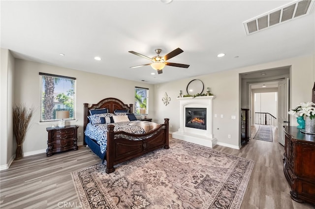 982 Camino Del Arroyo Dr Unit 49, San Marcos, CA 92078 - bedroom featuring light wood-style flooring, a glass covered fireplace, recessed lighting, and a ceiling fan