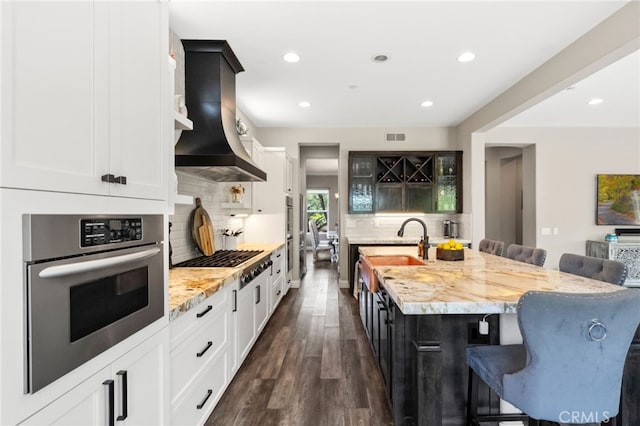 982 Camino Del Arroyo Dr Unit 49, San Marcos, CA 92078 - kitchen with appliances with stainless steel finishes, a breakfast bar area, island range hood, decorative backsplash, and recessed lighting