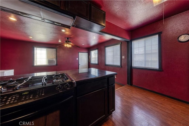 8933 Locust Ave, Fontana, CA 92335 - kitchen with black gas stove, a textured wall, wood finished floors, a textured ceiling, and ceiling fan