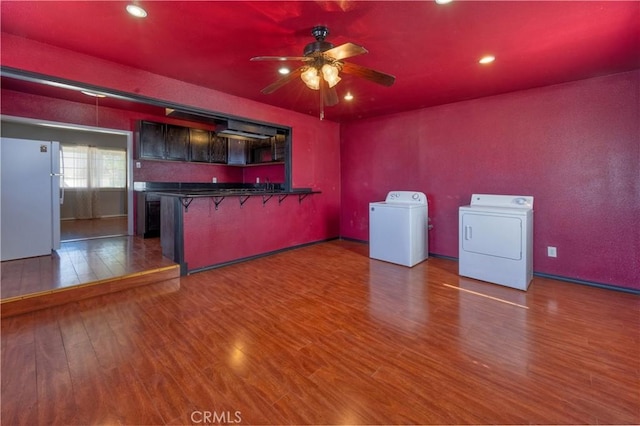 8933 Locust Ave, Fontana, CA 92335 - kitchen featuring separate washer and dryer, ceiling fan, dark countertops, wood finished floors, and a peninsula