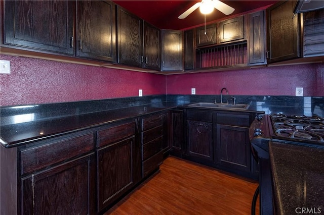 8933 Locust Ave, Fontana, CA 92335 - kitchen featuring dark brown cabinetry, a ceiling fan, wood finished floors, gas stove, and a textured wall