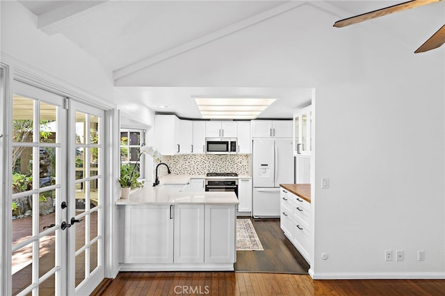 24802 La Plata Dr, Laguna Niguel, CA 92677 - kitchen featuring white fridge with ice dispenser, stainless steel microwave, dark wood-style floors, and a peninsula