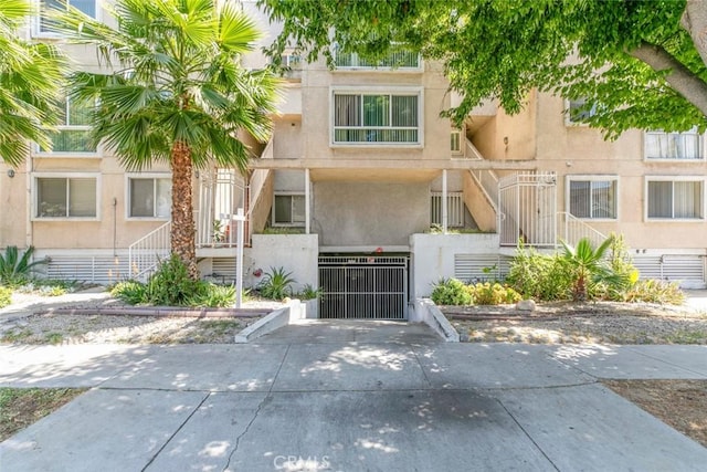 116 W Maple St Unit 25, Glendale, CA 91204 - view of property with a fenced front yard, concrete driveway, stairway, and a garage