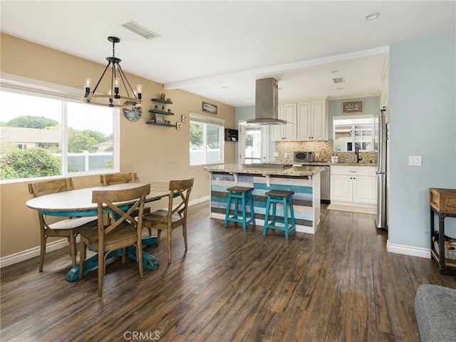 5243 E Monlaco Rd, Long Beach, CA 90808 - dining space featuring dark wood-style floors and a chandelier