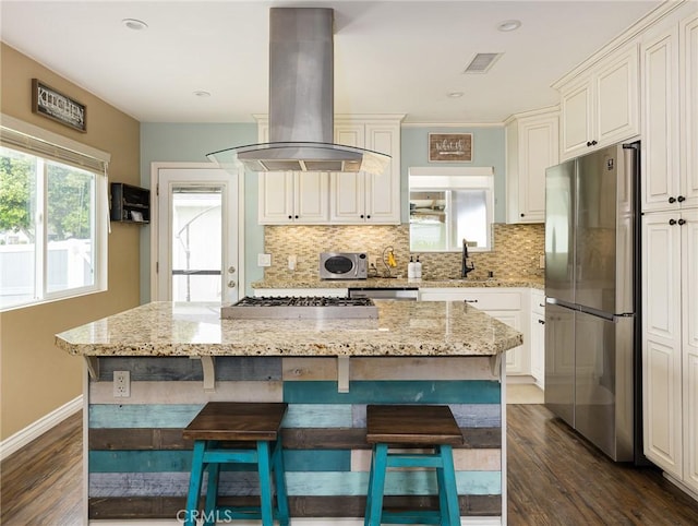 5243 E Monlaco Rd, Long Beach, CA 90808 - kitchen with appliances with stainless steel finishes, ventilation hood, dark wood-style flooring, tasteful backsplash, and a kitchen island