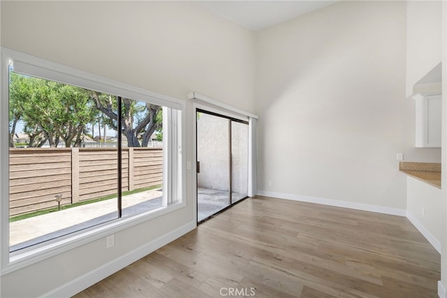 17842 Beard Ln Unit 88, Huntington Beach, CA 92647 - unfurnished dining area with plenty of natural light, a high ceiling, and light wood-style floors
