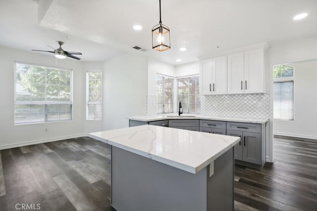 14226 Remington Ct, Fontana, CA 92336 - kitchen with gray cabinets, dark wood-type flooring, recessed lighting, decorative backsplash, and healthy amount of natural light