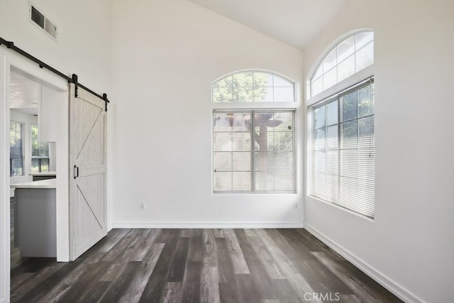 14226 Remington Ct, Fontana, CA 92336 - unfurnished dining area featuring a barn door, healthy amount of natural light, dark wood finished floors, and high vaulted ceiling