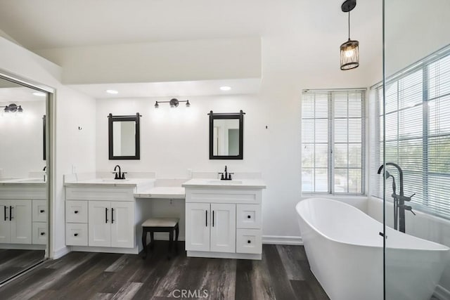 14226 Remington Ct, Fontana, CA 92336 - full bath with wood finished floors, a soaking tub, two vanities, plenty of natural light, and recessed lighting