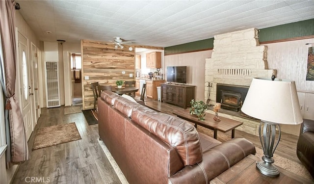 41394 Valley Of The Falls Dr, Forest Falls, CA 92339 - living room featuring wood finished floors, a ceiling fan, wooden walls, and a wood stove