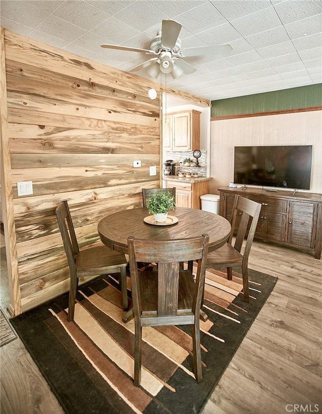 41394 Valley Of The Falls Dr, Forest Falls, CA 92339 - dining area featuring wood walls, ceiling fan, and light wood-style floors