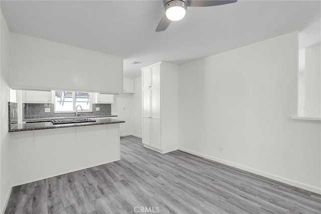 24933 Dracaea Ave, Moreno Valley, CA 92553 - kitchen with white cabinets, a peninsula, ceiling fan, and light wood-style floors