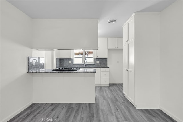 24933 Dracaea Ave, Moreno Valley, CA 92553 - kitchen featuring gas cooktop, white cabinetry, light wood-style floors, and backsplash
