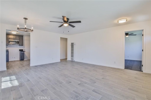 1026 W 109th St, Los Angeles, CA 90044 - unfurnished living room featuring a ceiling fan, a chandelier, and light wood-style floors