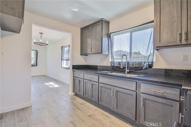 1026 W 109th St, Los Angeles, CA 90044 - kitchen featuring plenty of natural light, a chandelier, dark stone countertops, and light wood-style floors