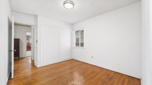 3139 W 152nd Pl, Gardena, CA 90249 - unfurnished bedroom with light wood-style floors, a textured ceiling, a closet, and multiple windows