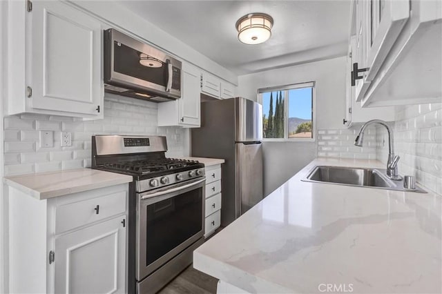 250 W Spazier Ave Unit 209, Burbank, CA 91502 - kitchen featuring appliances with stainless steel finishes, white cabinetry, backsplash, and light stone countertops