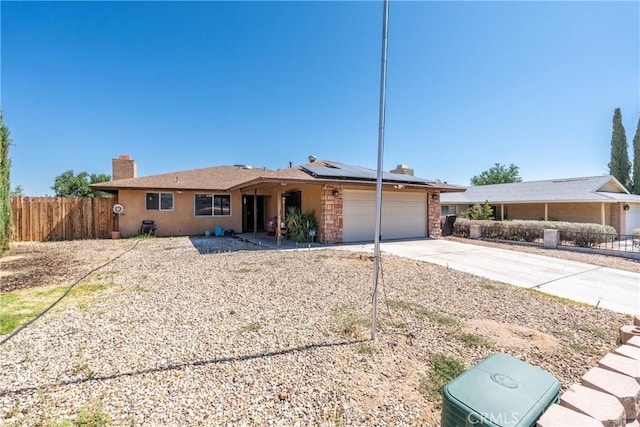 1267 Joshua Tree Dr, Barstow, CA 92311 - single story home featuring a chimney, solar panels, concrete driveway, a garage, and stone siding