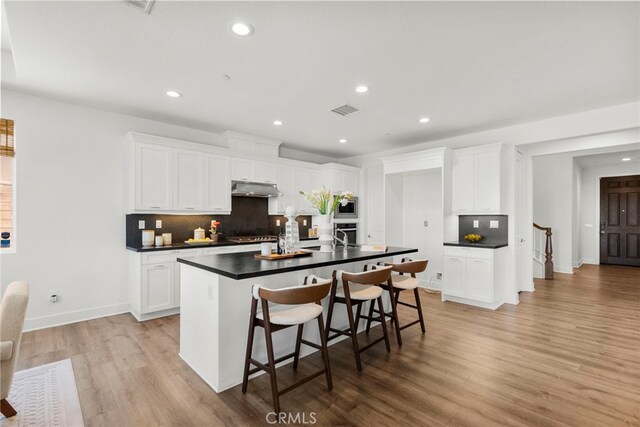19162 Lauren Ln, Saugus, CA 91350 - kitchen featuring dark countertops, under cabinet range hood, appliances with stainless steel finishes, decorative backsplash, and recessed lighting