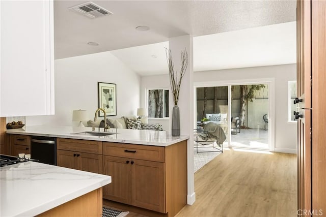 16917 Eric Ave, Cerritos, CA 90703 - kitchen featuring brown cabinetry, light stone counters, light wood-type flooring, dishwashing machine, and vaulted ceiling
