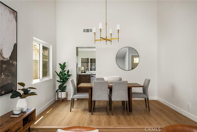 16917 Eric Ave, Cerritos, CA 90703 - dining space featuring a chandelier, light wood-style floors, and a high ceiling
