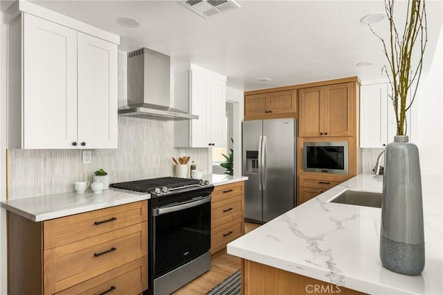 16917 Eric Ave, Cerritos, CA 90703 - kitchen with wall chimney range hood, stainless steel appliances, backsplash, and light stone countertops