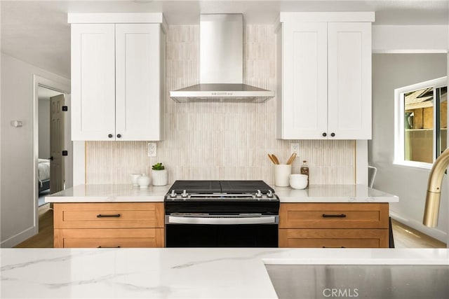 16917 Eric Ave, Cerritos, CA 90703 - kitchen featuring wall chimney range hood, gas stove, decorative backsplash, light stone counters, and white cabinetry