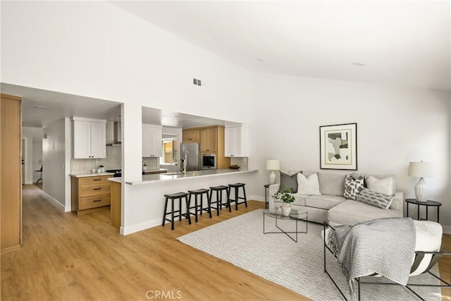 16917 Eric Ave, Cerritos, CA 90703 - living area with light wood-style floors and high vaulted ceiling