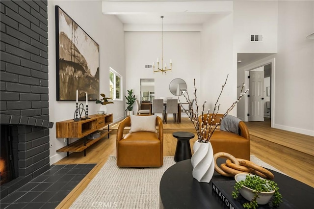 16917 Eric Ave, Cerritos, CA 90703 - living room with a brick fireplace, wood finished floors, a towering ceiling, and a chandelier