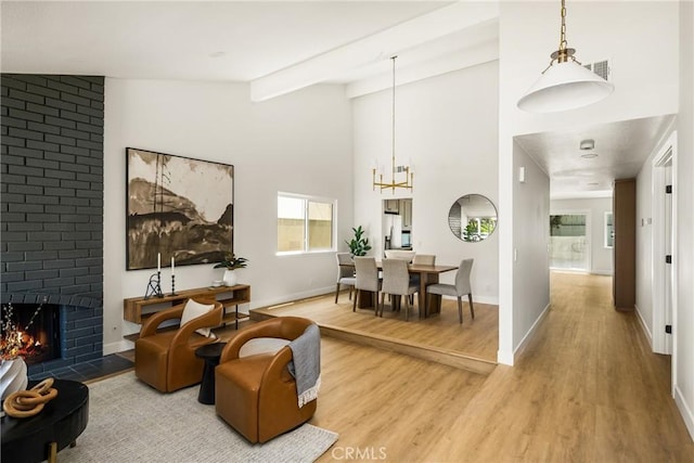 16917 Eric Ave, Cerritos, CA 90703 - living area featuring light wood-type flooring, a brick fireplace, and a chandelier