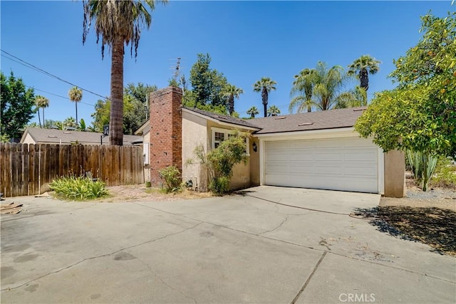 8084 Magnolia Ave, Riverside, CA 92504 - view of front of home featuring stucco siding, concrete driveway, an attached garage, and a chimney