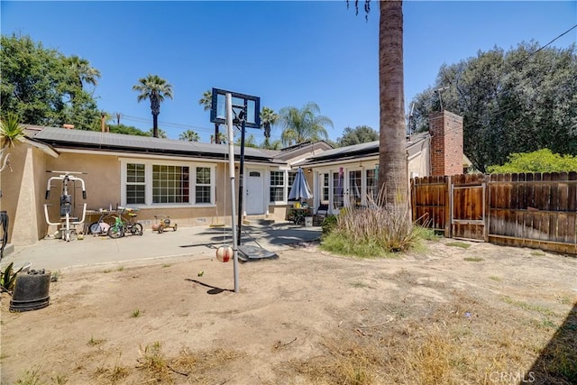 8084 Magnolia Ave, Riverside, CA 92504 - rear view of house featuring roof mounted solar panels, stucco siding, a patio, and french doors