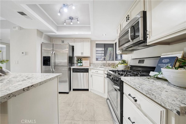 28191 Sorrento Unit 111, Laguna Niguel, CA 92677 - kitchen with stainless steel appliances, a tray ceiling, light marble finish floors, light stone counters, and white cabinets