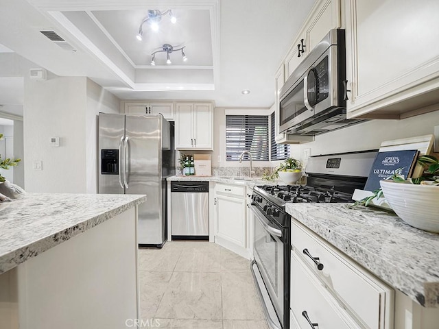28191 Sorrento Unit 111, Laguna Niguel, CA 92677 - kitchen featuring appliances with stainless steel finishes, a raised ceiling, light stone counters, white cabinetry, and light marble finish floors