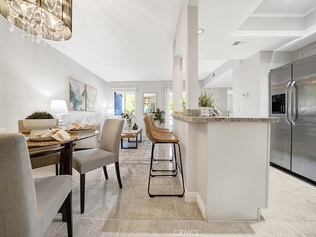 28191 Sorrento Unit 111, Laguna Niguel, CA 92677 - kitchen featuring stainless steel refrigerator with ice dispenser, a chandelier, open floor plan, and light stone countertops